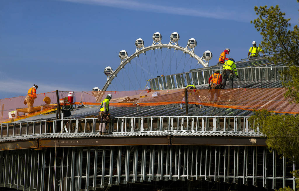 A construction crew works on the roof of a new pavilion at Wynn Golf Club on Tuesday, July 30, ...