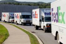 FILE - In this June 26, 2019, file photo delivery vehicles depart the FedEx Ship Center in Cran ...