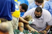 A fan is helped after being hit by a foul ball during the ninth inning of a baseball game betwe ...
