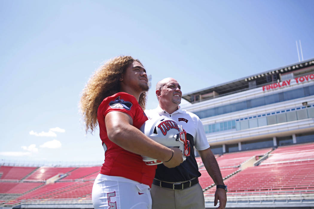 UNLV Rebels defensive lineman Naki Fahina (42) poses with head coach Tony Sanchez during the fo ...