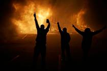 In a Nov. 25, 2014, file photo, people watch as stores burn in Ferguson, Mo. Michael Brown's de ...