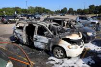 This Tuesday, Aug. 6, 2019 photo shows two charred vehicles in the parking lot of a Walmart in ...