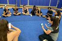 Tiffany Boulter, right, discusses dance routines with her cheer squad as they take a break from ...