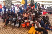 Migrants are seen aboard the Open Arms Spanish humanitarian boat as it cruises in the Mediterra ...