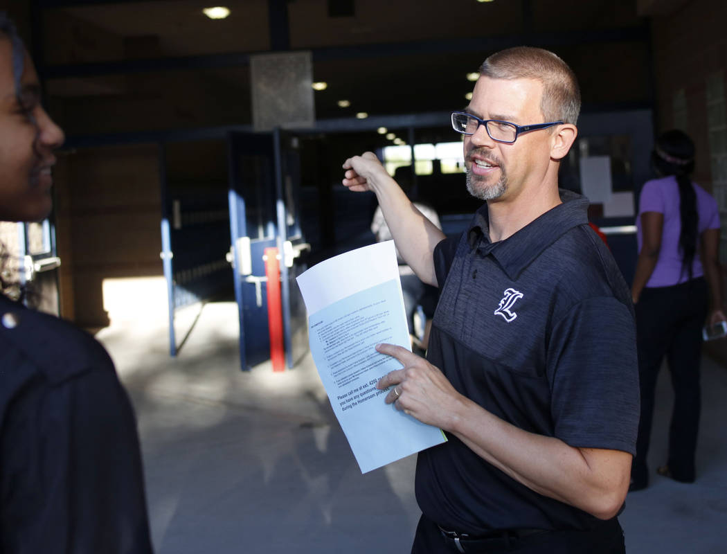 Orchestra teacher Ryan Dudder helps direct students to their homerooms on the first day of scho ...