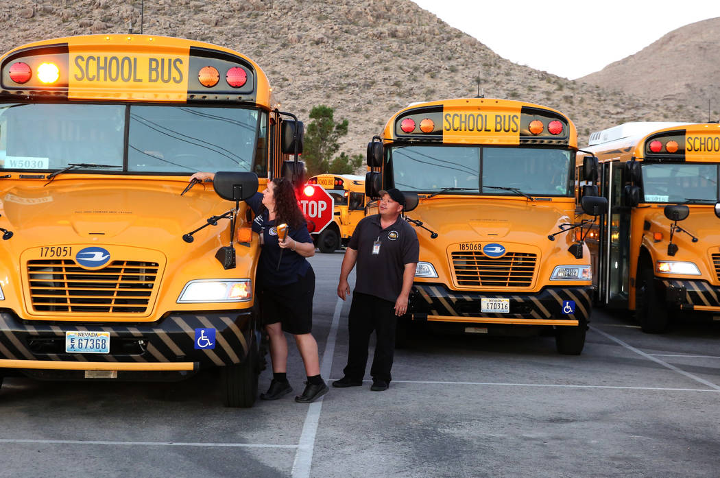 Clark County School District bus driver Christy Mattson inspects her bus as her supervisor Kevi ...