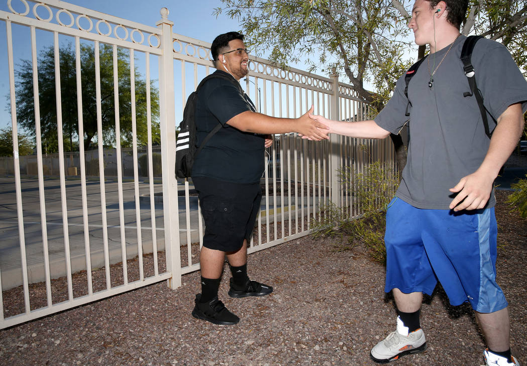 Sunrise Mountain High School junior Bryan Mungia, left, greets a friend who declined to give hi ...