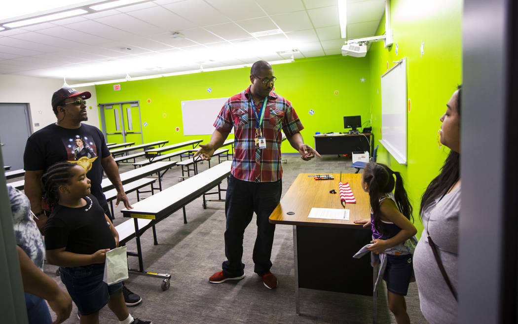 Physical education teacher Parnell Graham, left, talks with students and parents after a ribbon ...