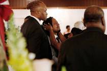 A relative attempts to console Dion Green, center, before the funeral for his father, Derrick F ...