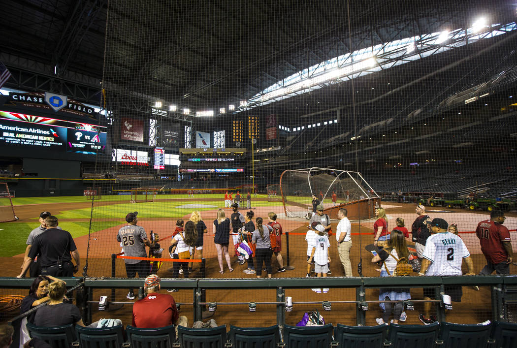 Baseball fans with early access watch teams practice before an Arizona Diamondbacks baseball ga ...