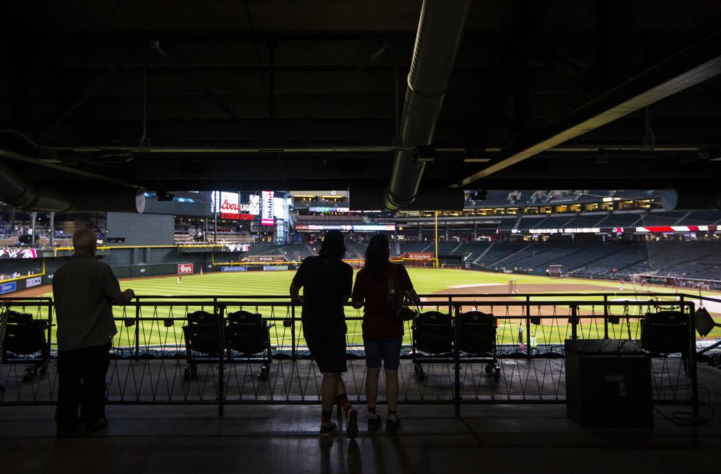 Baseball fans watch teams practice before an Arizona Diamondbacks baseball game against the Phi ...