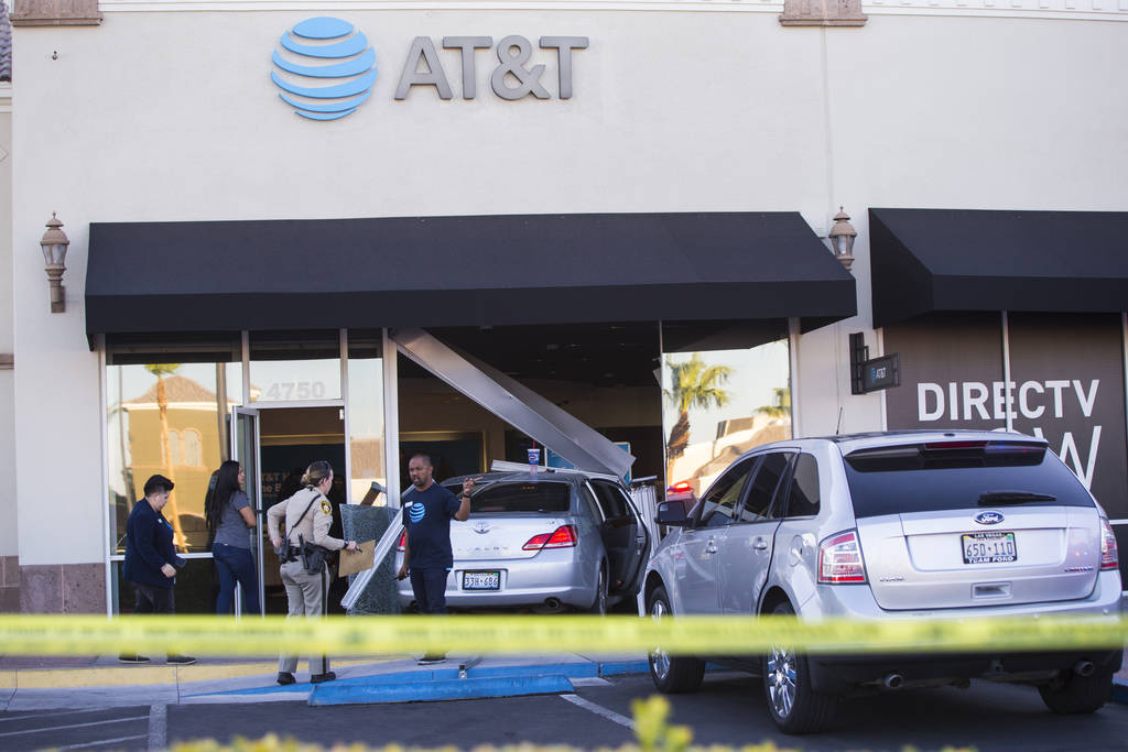 Las Vegas police investigate the scene where a driver in a car crashed into an AT&T store i ...