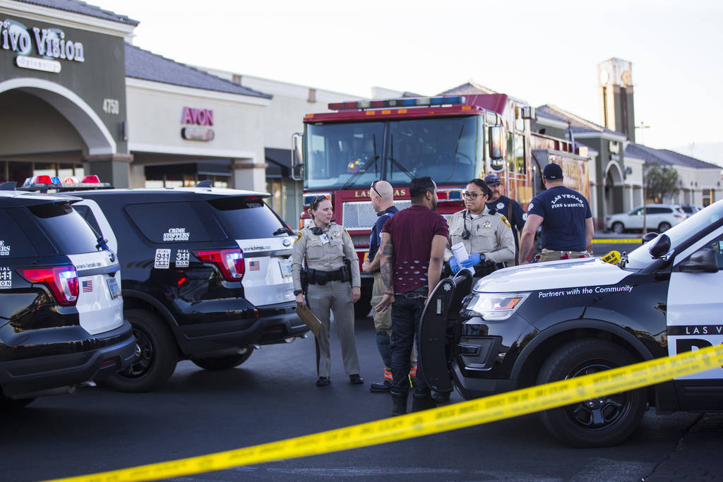 A man is detained by Las Vegas police as they investigate the scene where a driver in a car cra ...
