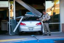 Las Vegas police investigate the scene where a driver in a car crashed into an AT&T store i ...