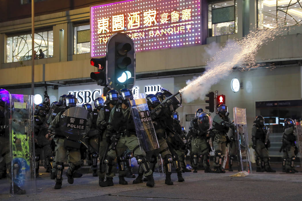 Riot police fire tear gas during the anti-extradition bill protest in Hong Kong, Sunday, Aug. 1 ...