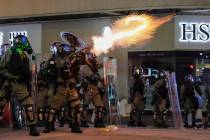 Riot police fire tear gas during the anti-extradition bill protest in Hong Kong, Sunday, Aug. 1 ...