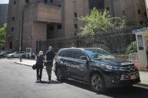 New York City medical examiner personnel leave their vehicle and walk to the Manhattan Correcti ...