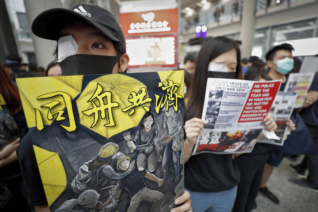 Protesters wear eyepatch during a protest at the arrival hall of the Hong Kong International Ai ...