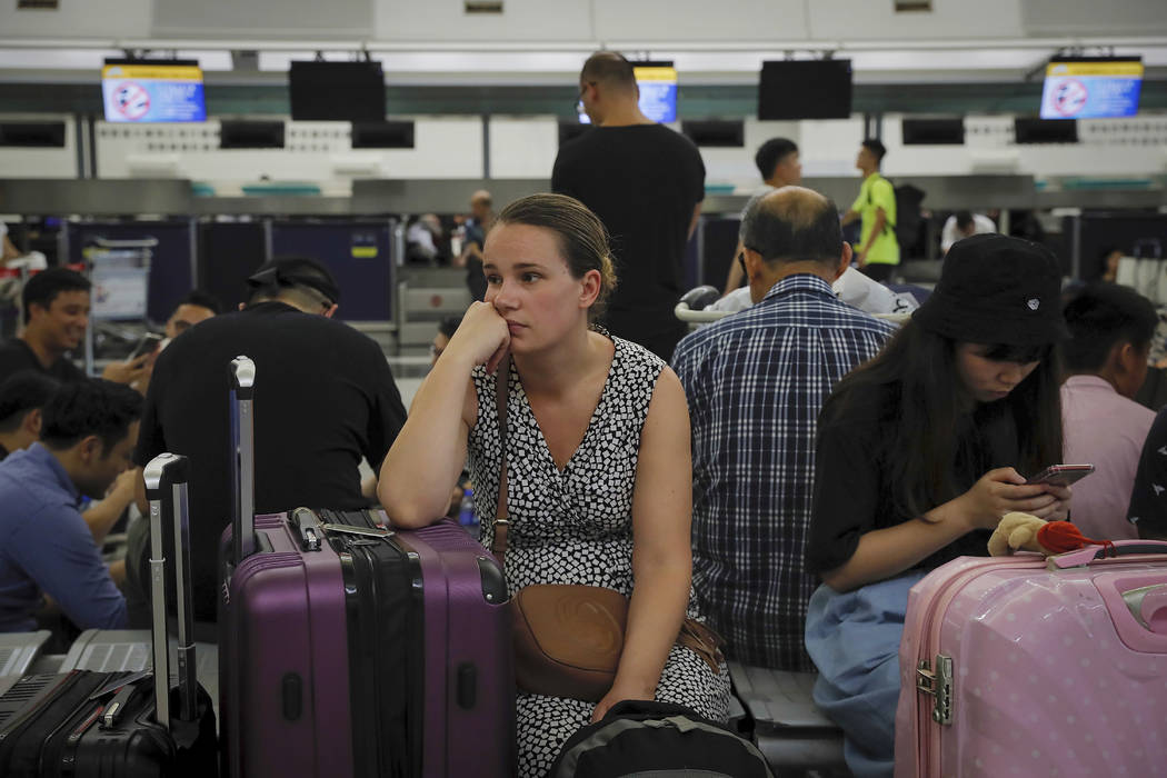 Australian Penny Tilley, center, reacts next to stranded travelers at the closed check-in count ...