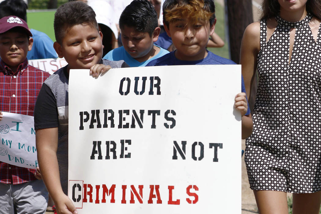Children of mainly Latino immigrant parents hold signs in support of them and those individuals ...