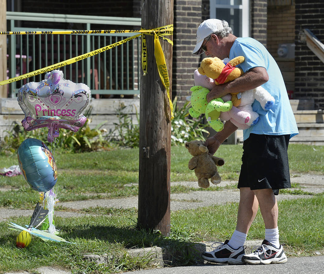 Paul Laughlin, 57, places stuffed animals on Sunday, Aug. 11, 2019 outside a home in Erie, Pa., ...