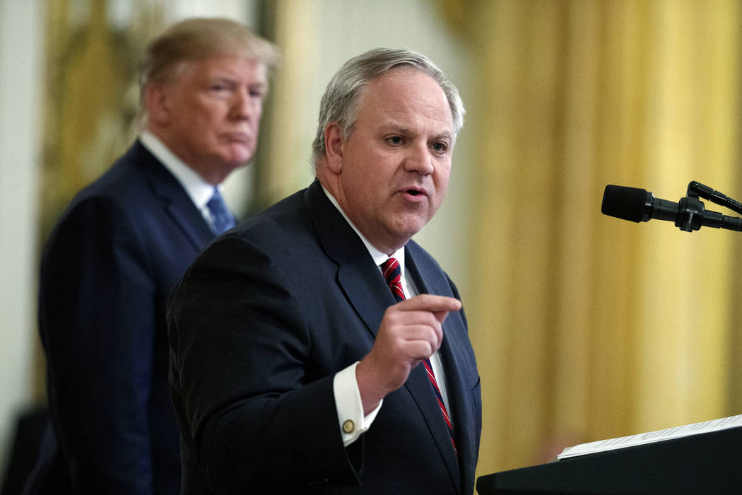 FILE - In this July 8, 2019 file photo President Donald Trump listens as Secretary of the Inter ...