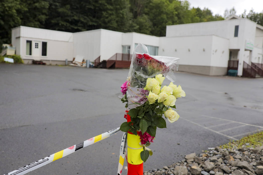 Flowers are left by a police cordon outside Al-Noor Islamic Centre Mosque in Baerum, Norway, Mo ...