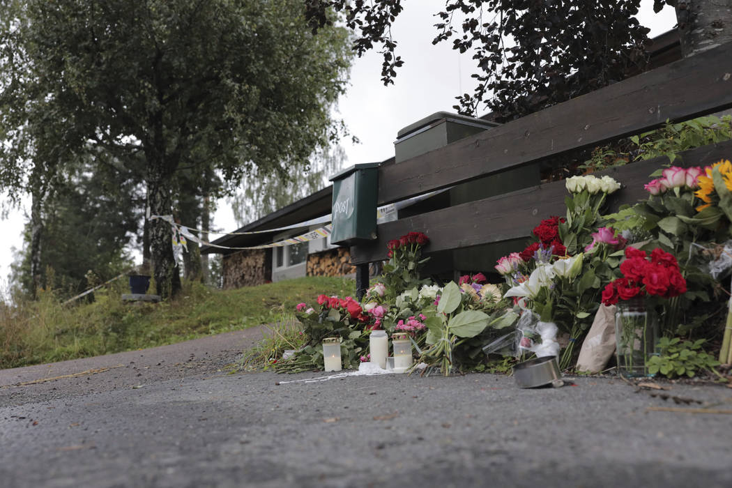 Flowers are left side of the house where the body of the stepsister of a suspected gunman was f ...