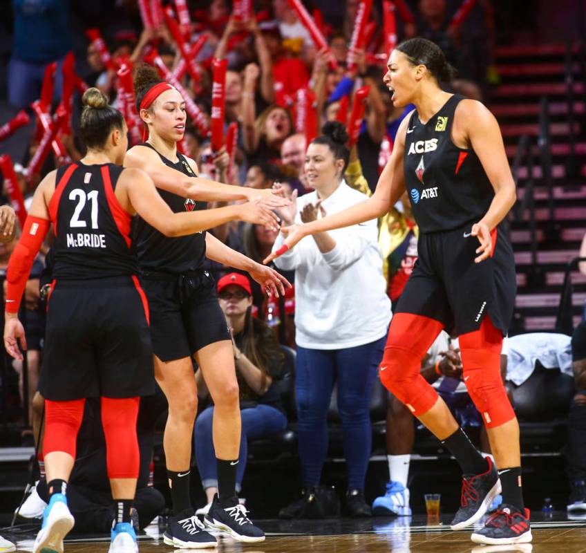 Las Vegas Aces' Liz Cambage, right, celebrates with teammates Kayla McBride (21) and Dearica Ha ...