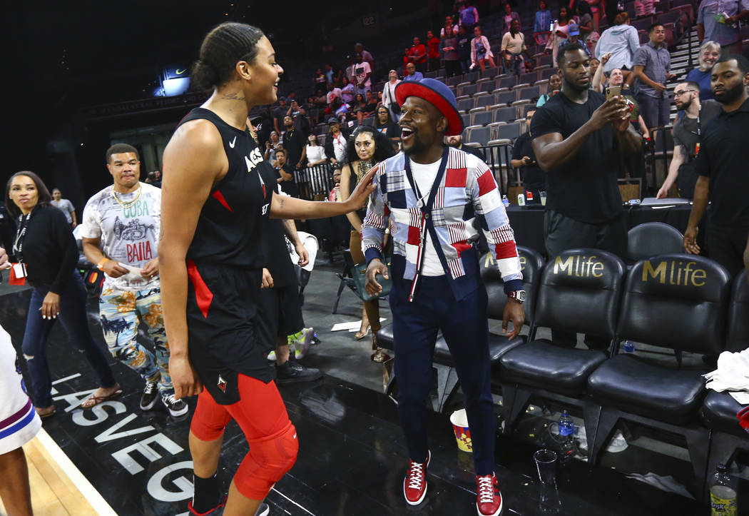 Las Vegas Aces' Liz Cambage talks with boxer Floyd Mayweather after a WNBA basketball game at t ...