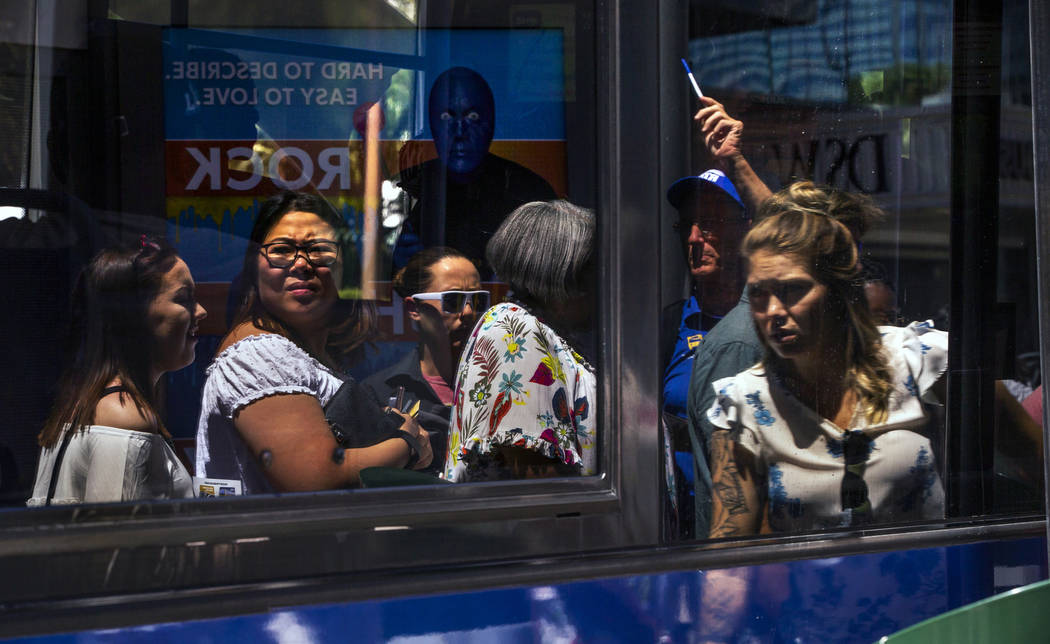 Passengers are reflected in the window of an RTC bus as they get on the bus near the MGM Grand ...