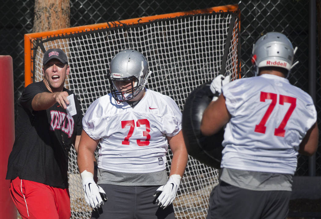UNLV offensive coordinator Garin Justice, left, coaches up the Rebels during the first day of t ...
