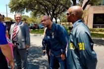 FBI agents examine the scenes Tuesday, August 13, 2019 where someone fired shots at two buildin ...