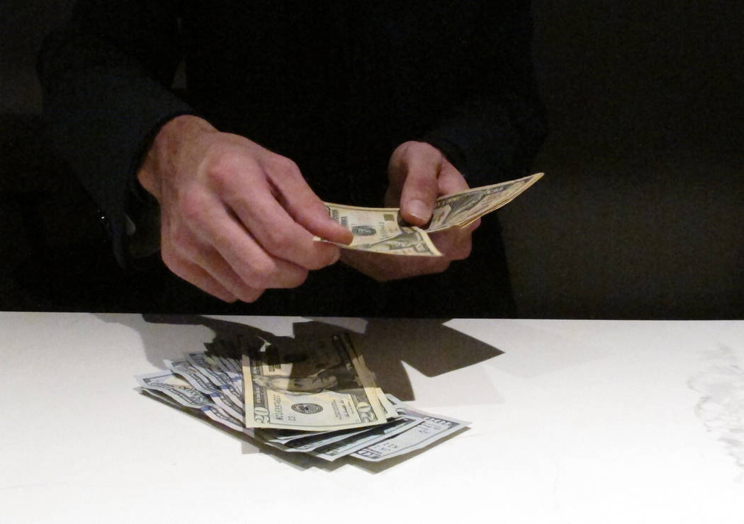 In this June 27, 2019 photo, a clerk counts money at the new sportbook at Bally's casino in Atl ...