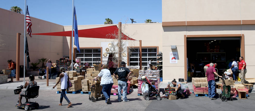 People pick up food during a food bank distribution at Veterans Village in downtown Las Vegas, ...