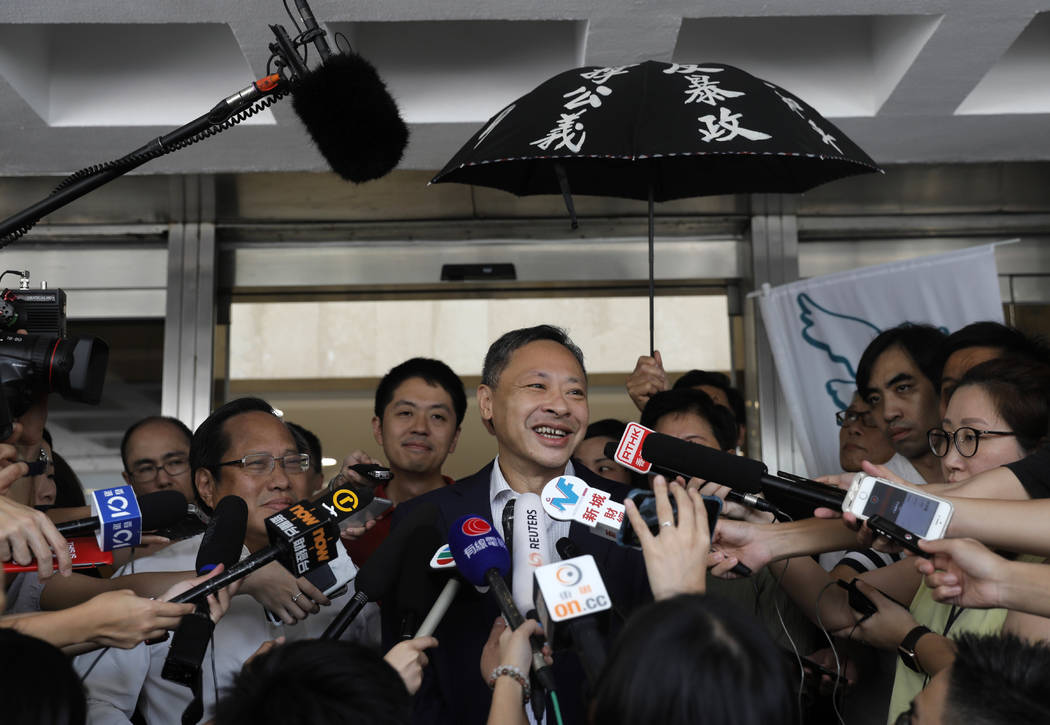 Occupy Central leader Benny Tai, center, talks to reporters outside the High court in Hong Kong ...