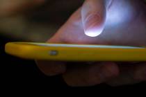 In a Sunday, Aug. 11, 2019, photo, a man uses a cell phone in New Orleans. With suicides on the ...