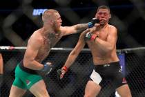 Conor McGregor, left, connects a left punch against Nate Diaz in the welterweight bout during U ...