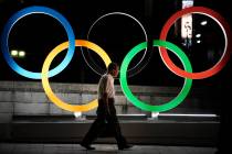 A man walks past the Olympic rings Tuesday, July 23, 2019, in Tokyo. (AP Photo/Jae C. Hong)