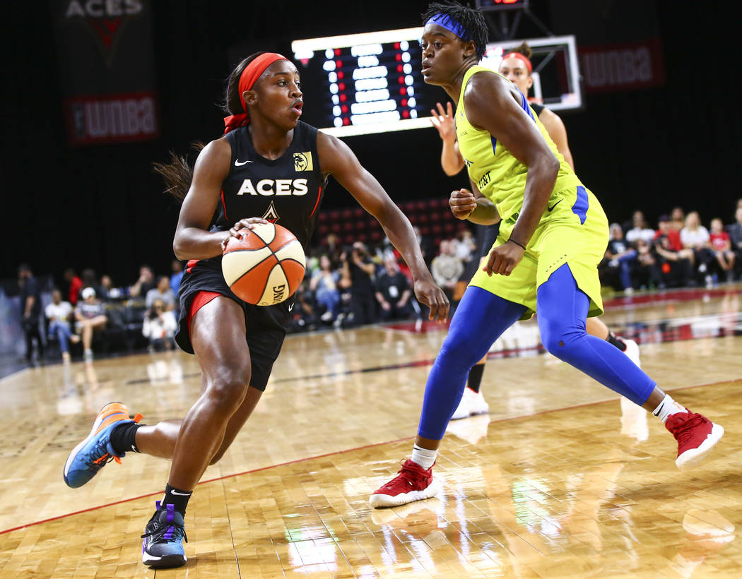 Las Vegas Aces' Jackie Young (0) drives to the basket against Dallas Wings' Kaela Davis (3) dur ...