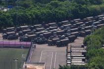 In this image made from video, armed police vehicles are parked outside Shenzhen Bay Stadium in ...