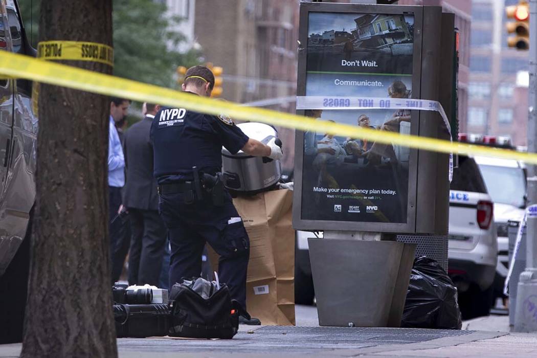 An investigator bags a suspicious package as evidence after it was thought to be an explosive d ...