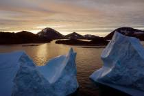An aerial view of large Icebergs floating as the sun rises near Kulusuk, Greenland, early Frida ...