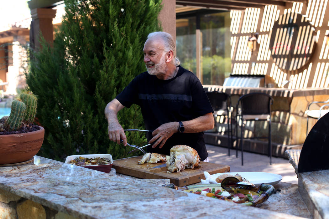 Hubert Keller, chef of Fleur de Lys and Fleur, cuts a rotisserie chicken in his backyard kitche ...