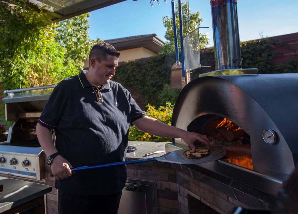 Matt Silverman, chef for HEXX Kitchen + Bar, pulls out flat bread from his pizza oven in his ba ...