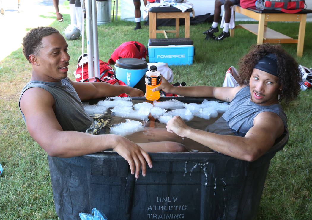 UNLV's linebacker Tre Caine, left, and defensive back Greg Francis, cool off in an ice bath aft ...