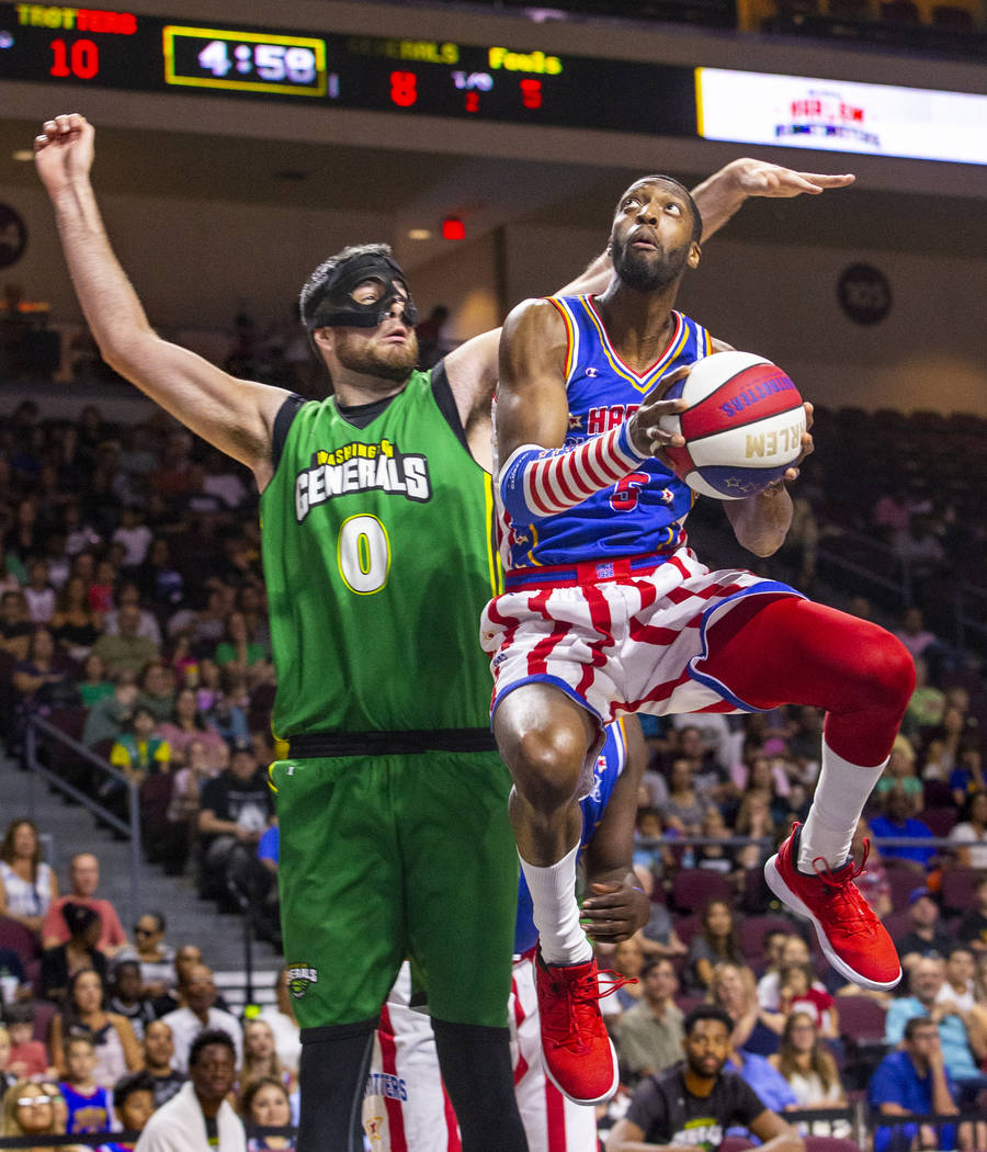 Harlem Globetrotter Bulldog Mack (5, right) soars past the Washington