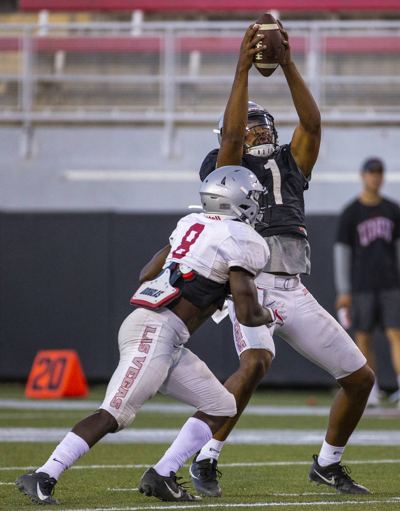 Quarterback Armani Rogers (1) reaches up to save a high snap during the UNLV football team scri ...