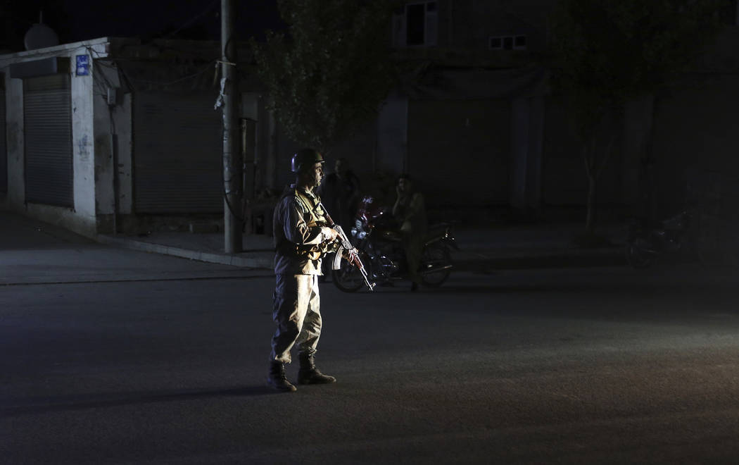 An Afghan police man stand guard outside the wedding hall after an explosion in Kabul, Afghanis ...