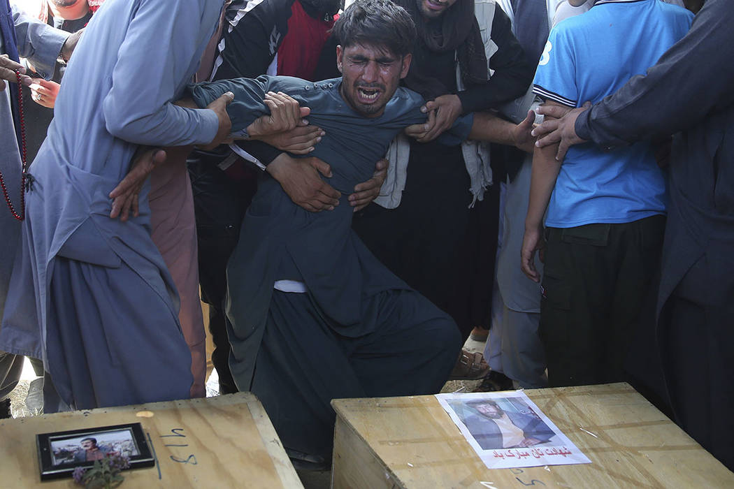 A relative wails near the coffins of victims of the Dubai City wedding hall bombing during a ma ...